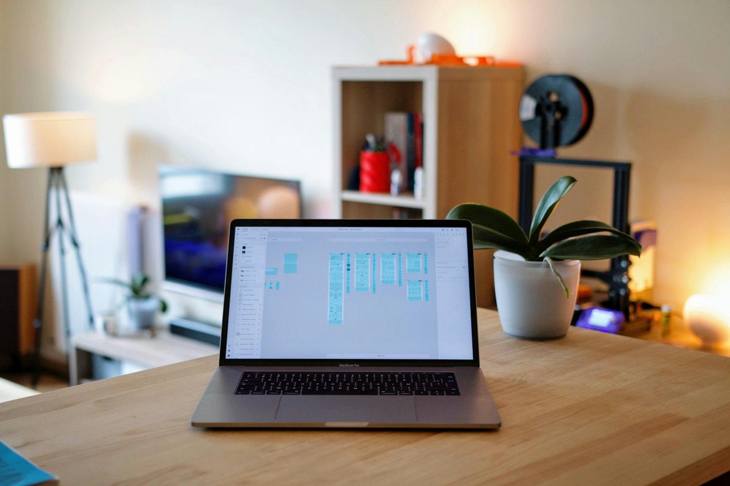 Risorse Computer portatile con interfaccia utente di un'applicazione di design su una scrivania di legno.
