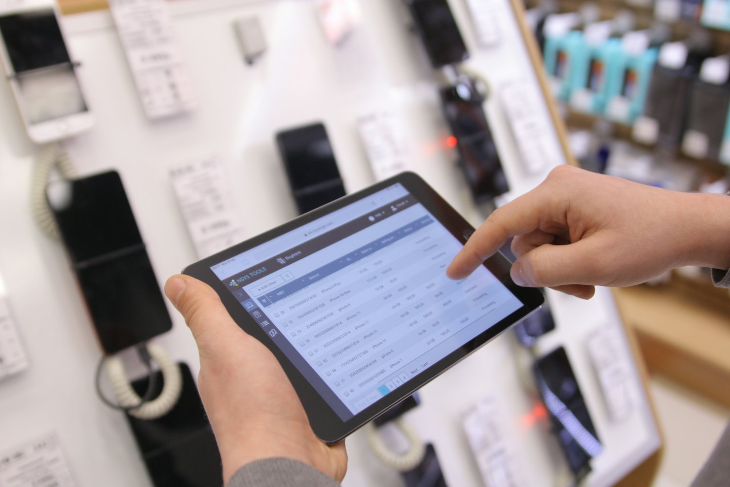 Servizi Mani che gestiscono l'inventario del negozio su uno schermo di tablet.